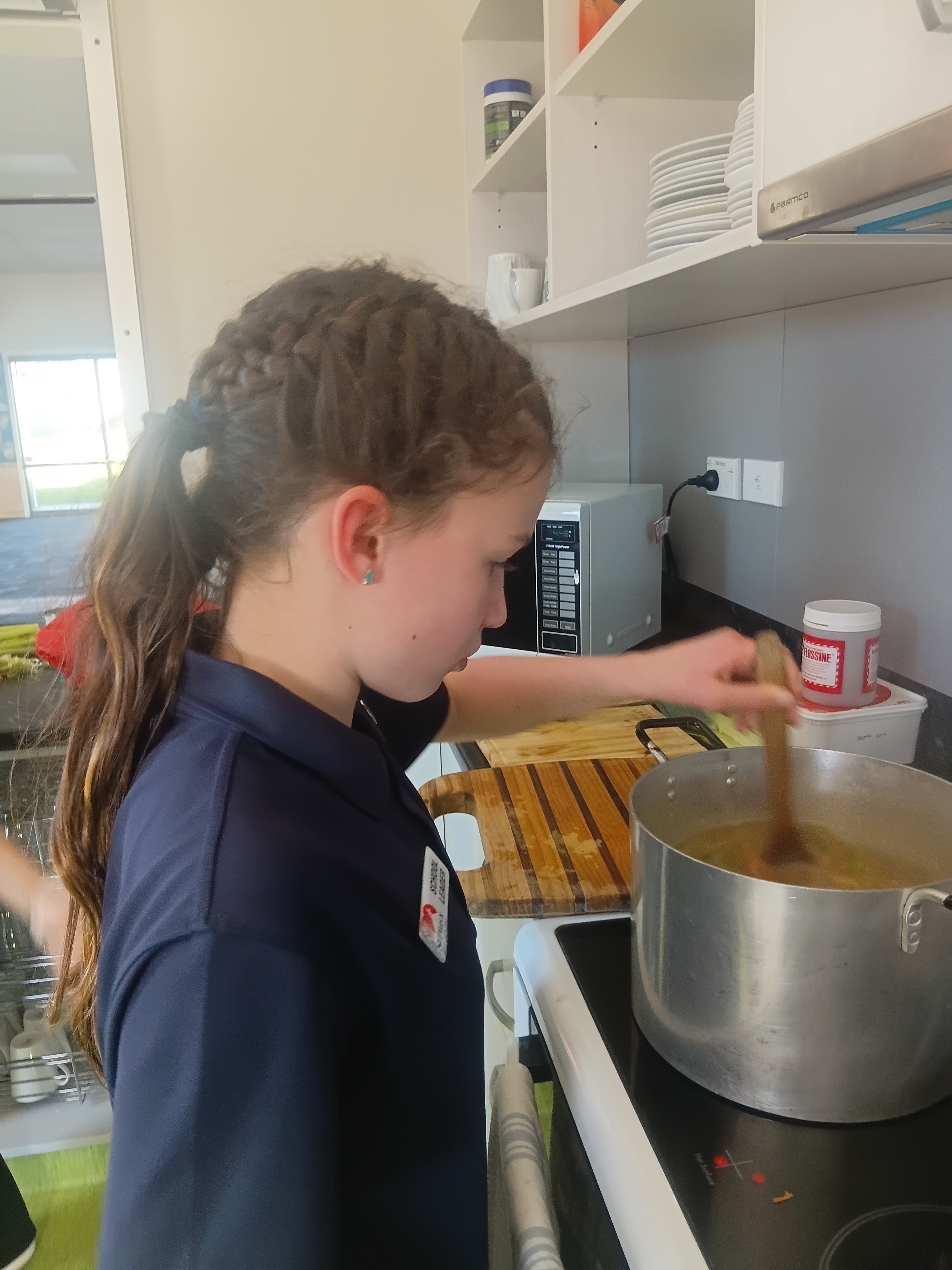 A school leader stirring soup for St Vincent de Paul community meals